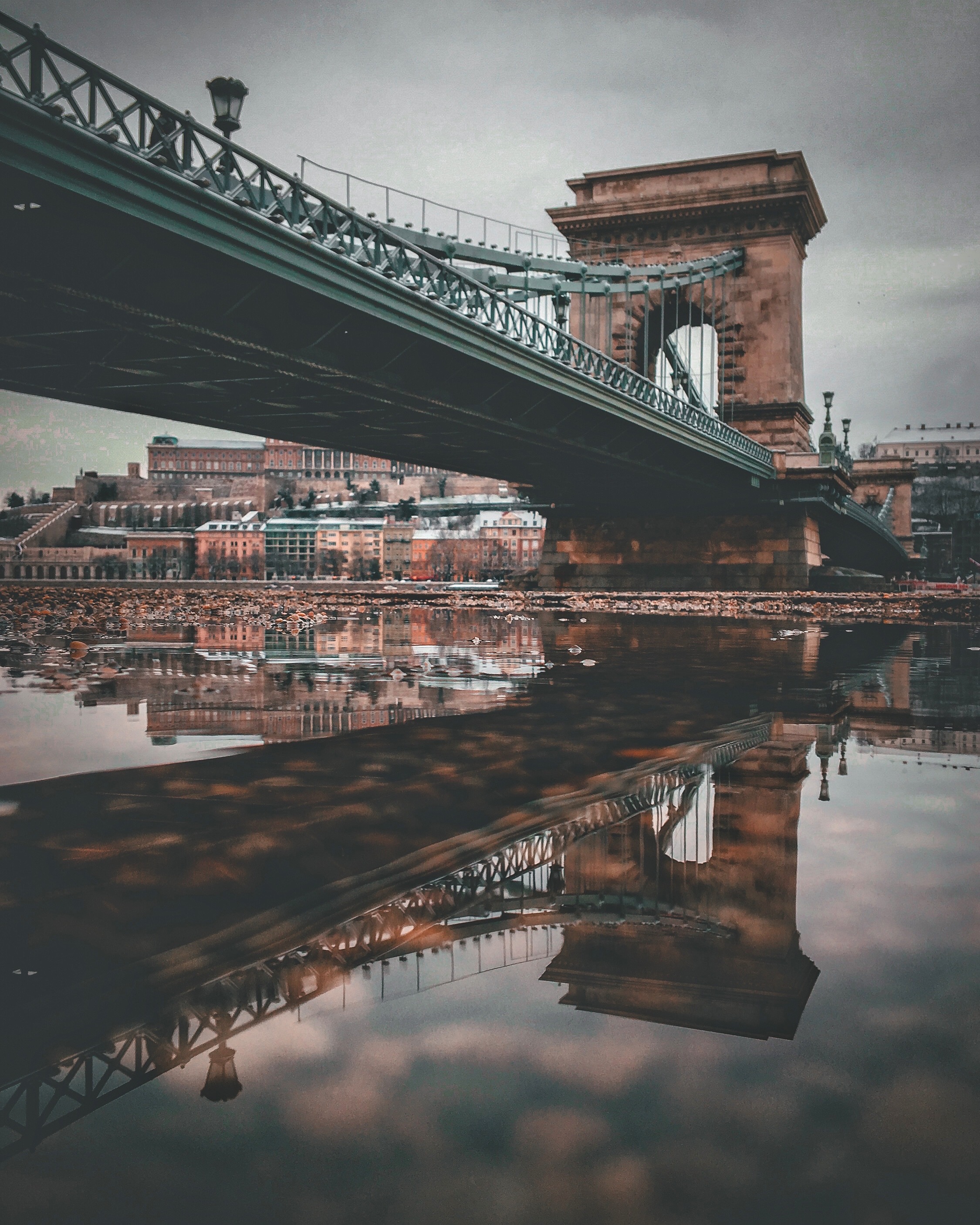 Lánchíd: Egy téli videóklip forgatás után megálltam a Lánchídnál a nagy dugó miatt, hogy kivárjam, amíg kicsit lecsendesül a forgalom. A Pontoon helyén sétálgatva, találtam egy pont jó helyen lévő pocsolyát. Klick-klick. És elkészült ez a szupertükrös kép.